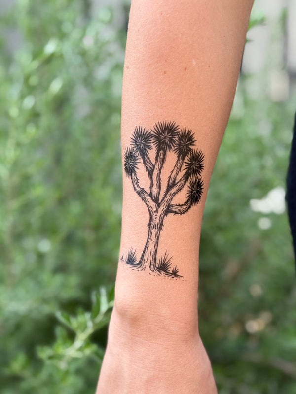 joshua tree temporary tattoo on a person's arm with a blurred green background