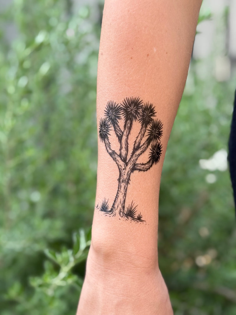 joshua tree temporary tattoo on a person's arm with a blurred green background