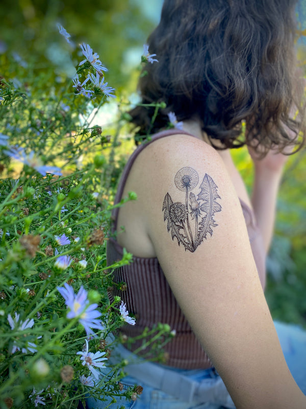 Dandelion temporary tattoo on shoulder with a floral background 