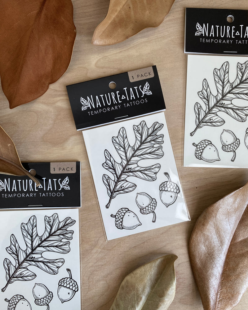 Nature-Tats temporary tattoos with leaf and acorn designs on a wooden surface.