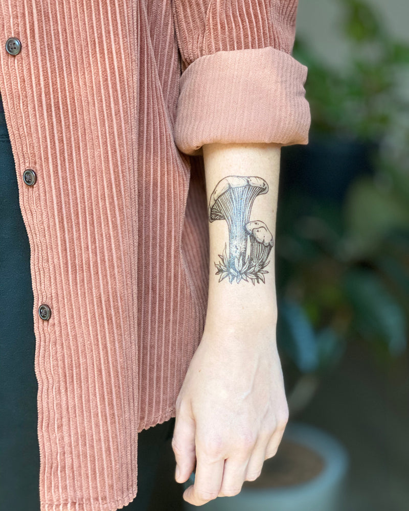 mushroom Temporary tattoo on arm with red and blurred nature background 