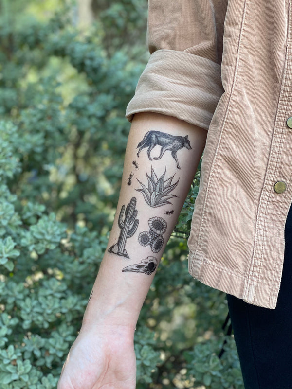 desert wild temporary tattoo on arm with a blurred green background 