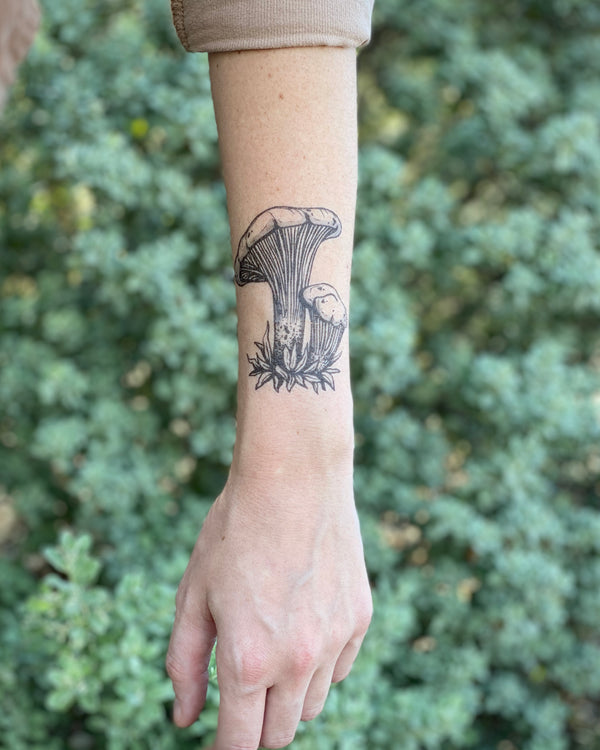 mushroom Temporary tattoo on arm with blurred green nature background 