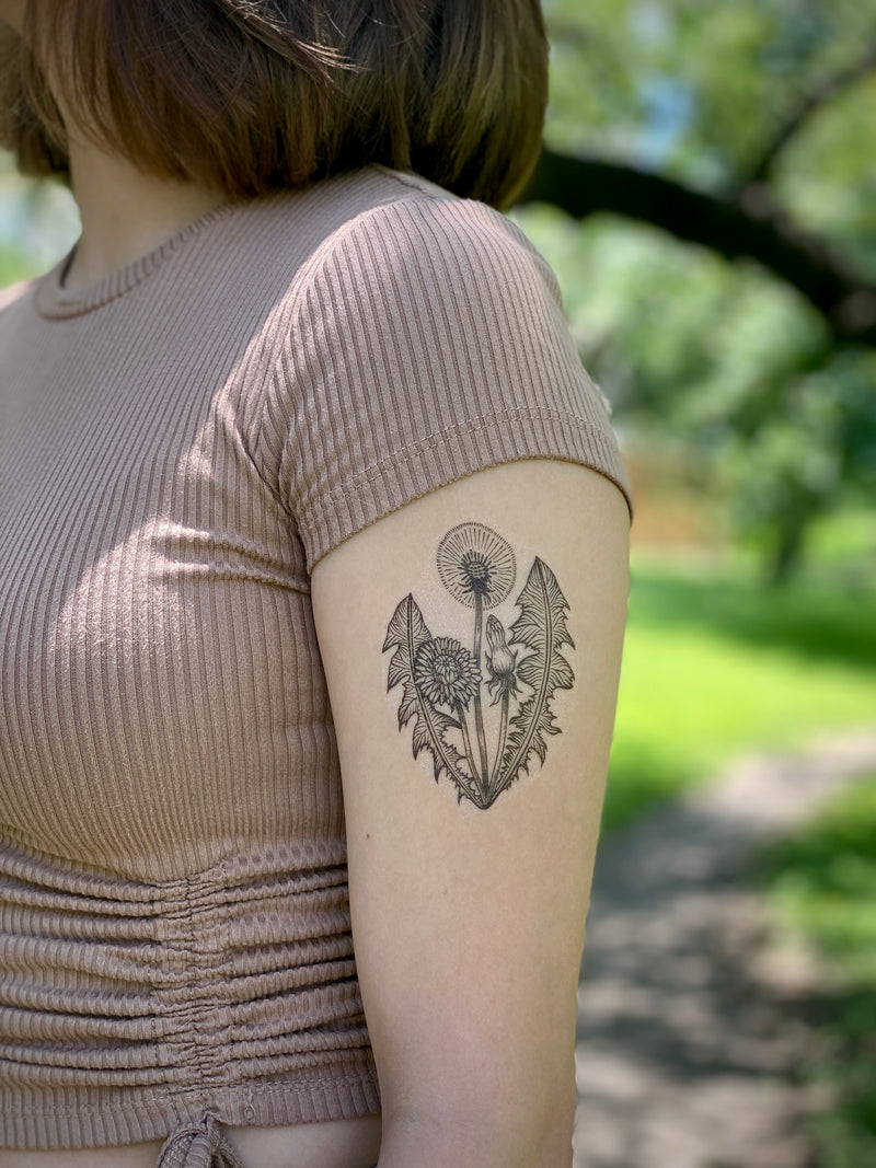Dandelion temporary tattoo with a blurred nature background 