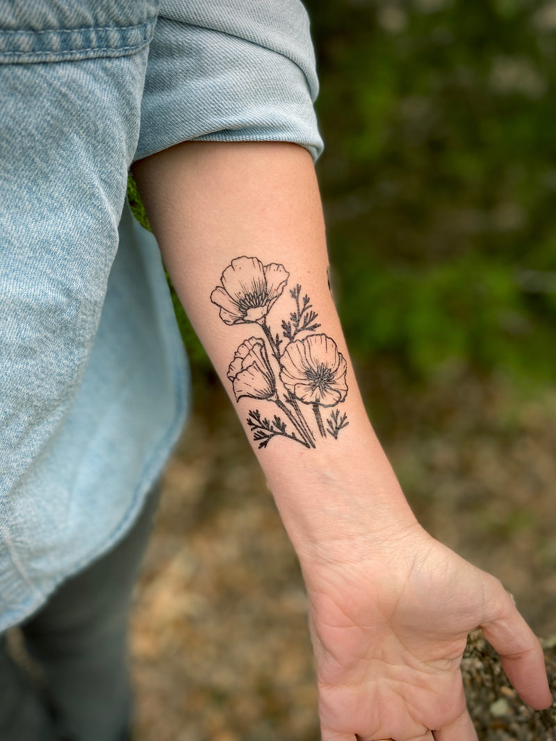 Temporary Tattoo of golden poppy flower design on a person's arm with a natural background