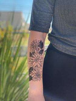 person wearing black ink dahlia temporary tattoo on forearm
