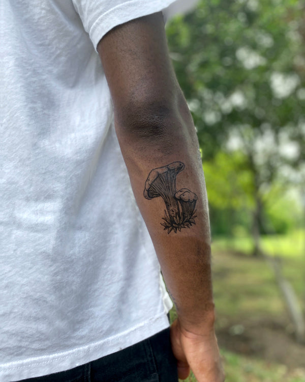 mushroom Temporary tattoo on back of the arm with a blurred nature background 