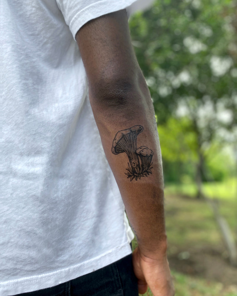 mushroom Temporary tattoo on back of the arm with a blurred nature background 