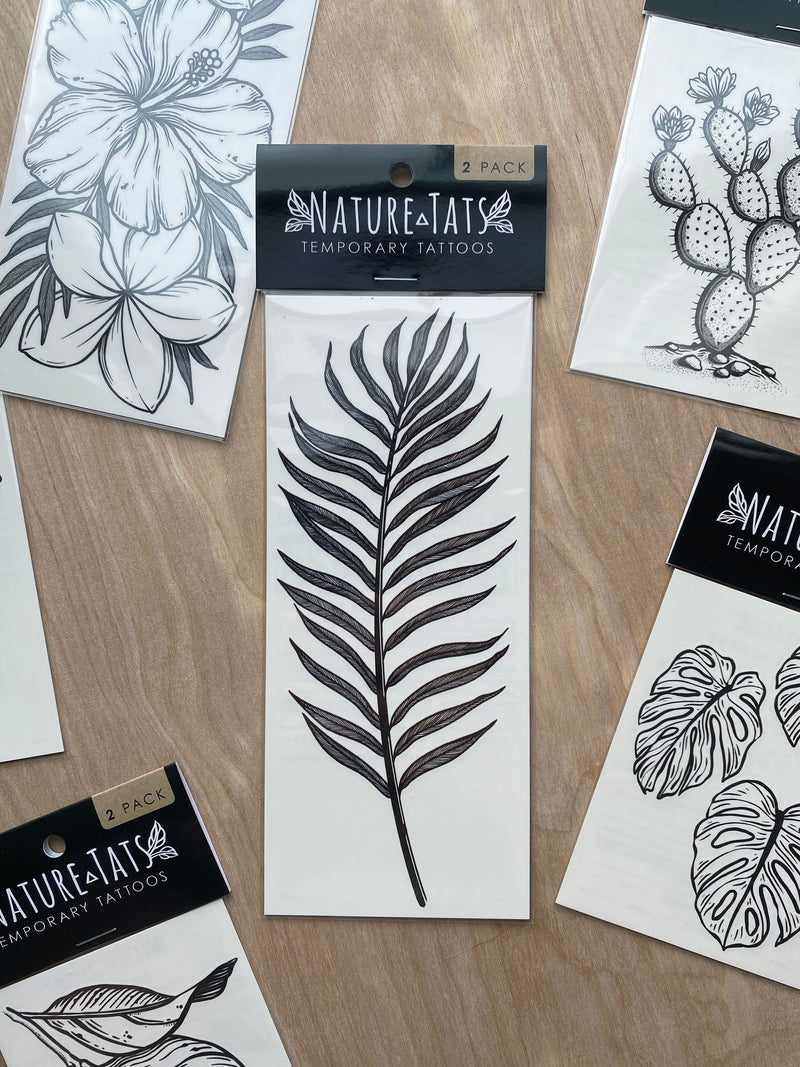 palm leaf temporary tattoo in packaging on a wood background 