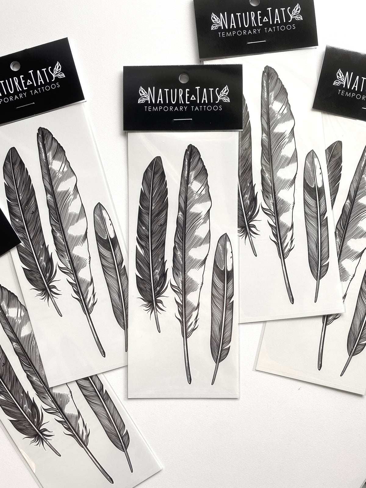 temporary tattoos of the feather finds design in packaging with a white background 
