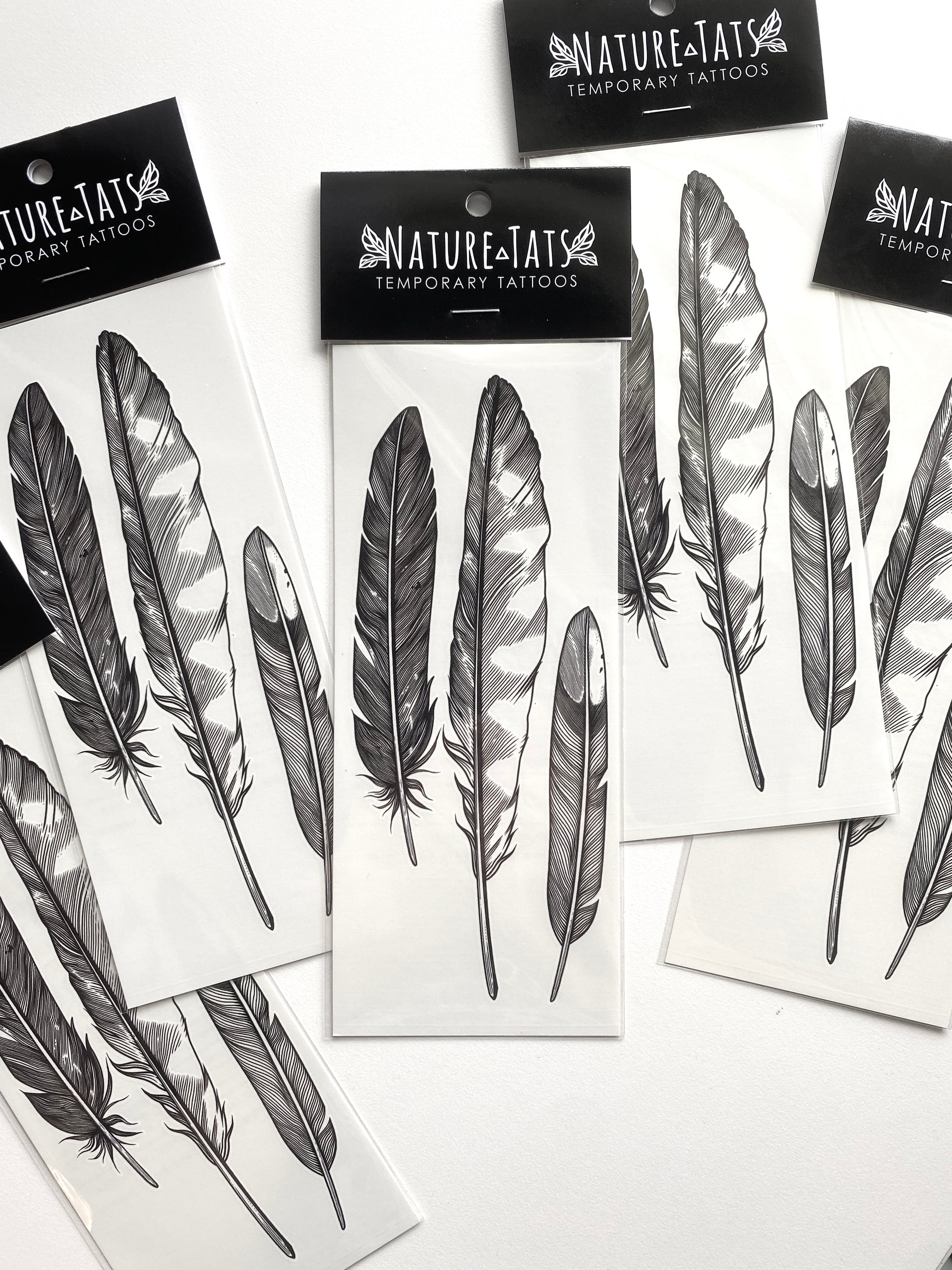 temporary tattoos of the feather finds design in packaging with a white background 