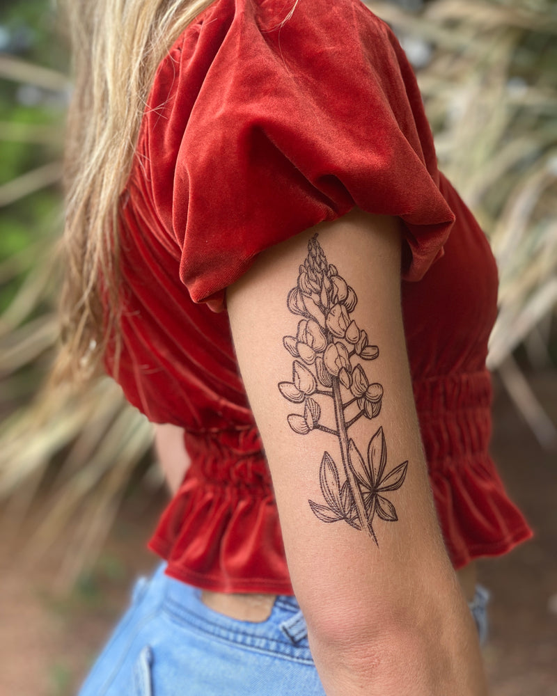 temporary tattoo of bluebonnet on a person arm with a nature background 