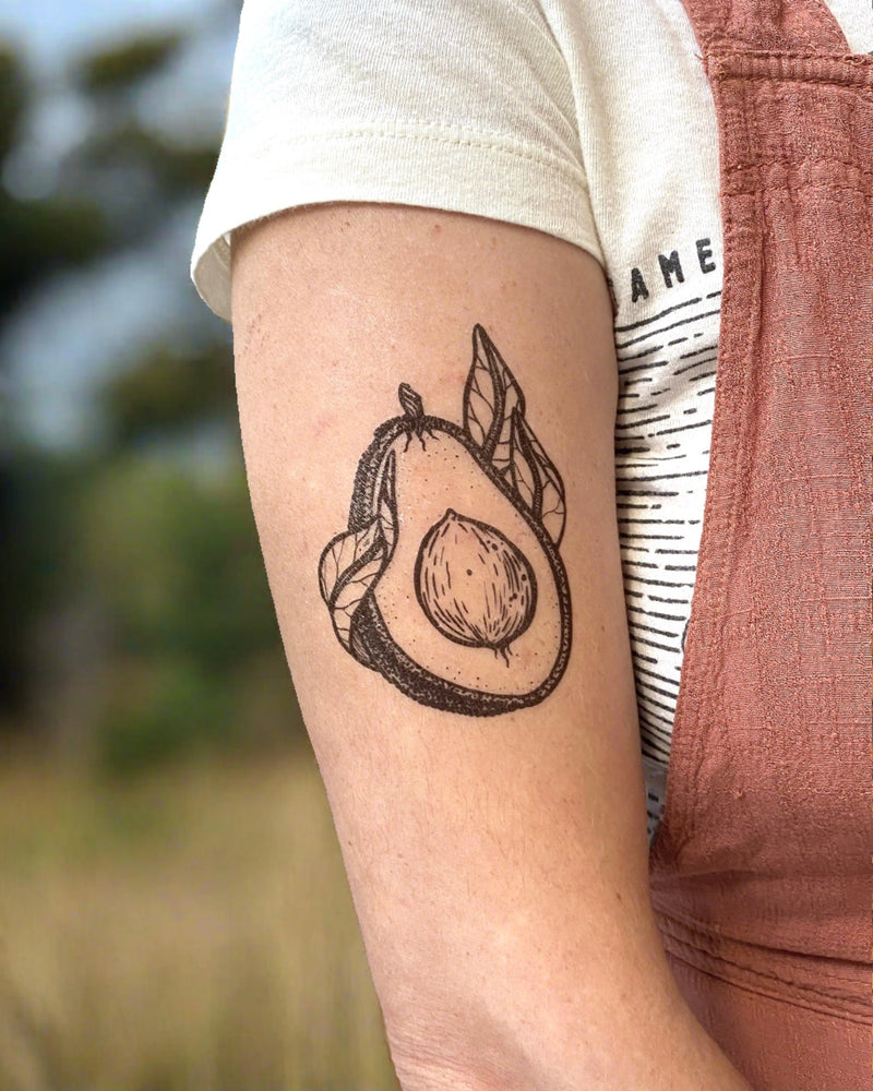 avocado temporary tattoo on a person arm with a nature background 
