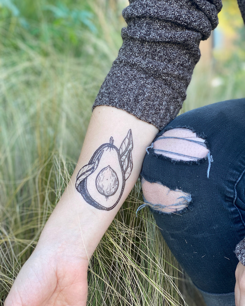 avocado temporary tattoo on a person arm in a green nature background 