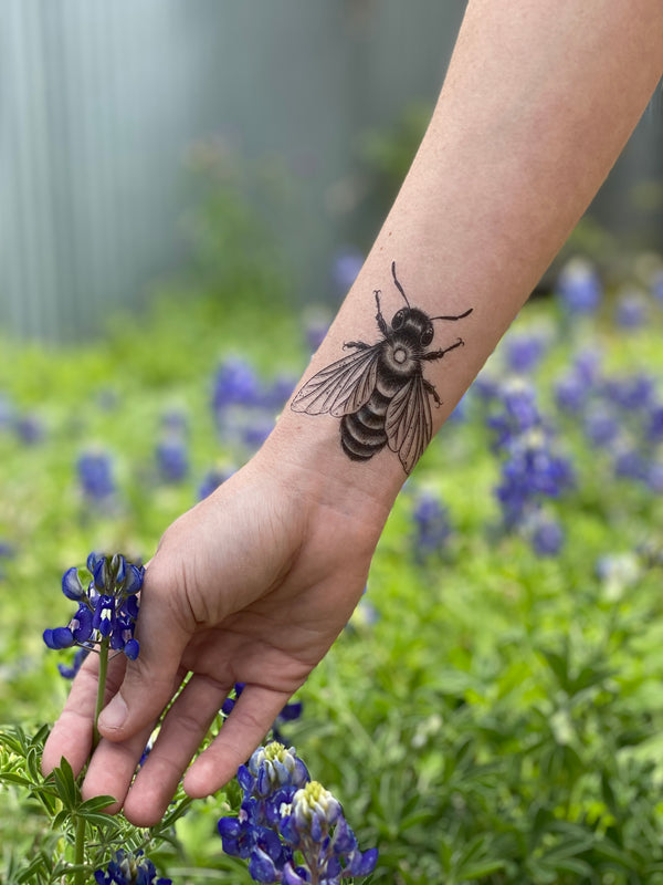 temporary tattoo of a bee with a nature background with flowers 