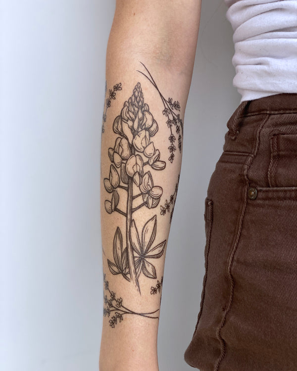 temporary tattoos on a person arm with a grey background 