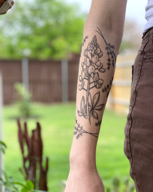 temporary tattoos on a persons arm with blurred nature background 