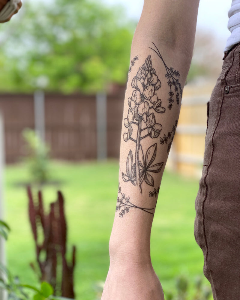 temporary tattoos on a persons arm with blurred nature background 
